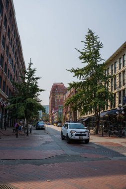 Şehir merkezinin Vancouver manzarası. Caddenin genel planı - eski ve modern binalar, yollar, ticari işletmeler güneşli yaz günlerinde. 