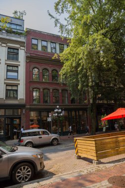 Şehir merkezinin Vancouver manzarası. Caddenin genel planı - eski ve modern binalar, yollar, ticari işletmeler güneşli yaz günlerinde. 