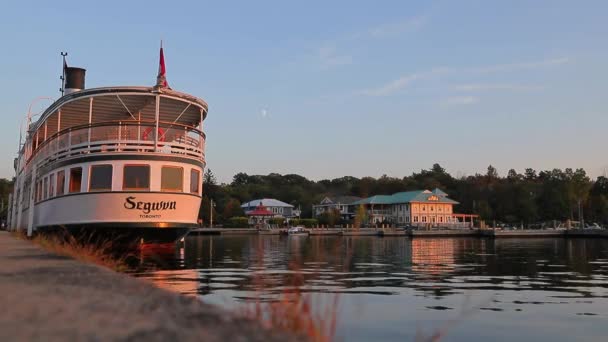 湖の夕日 暖かい日 穏やかな水 蒸気船が桟橋に立っている 貯水池のヴィンテージクルーズライナー 銀行に沿って散歩する グレイブンハースト オンタリオ カナダ — ストック動画
