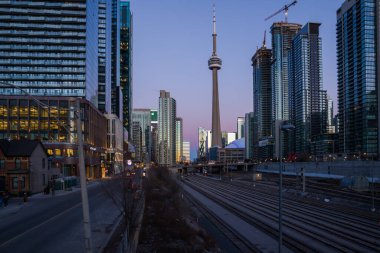Finans bölgesinde şehir merkezinde günbatımı. Demiryolu kavşağı, apartmanlar, ofis binaları aydınlatıldı. Skyline Toronto, Ontario, Kanada