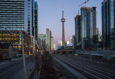 Finans bölgesinde şehir merkezinde günbatımı. Demiryolu kavşağı, apartmanlar, ofis binaları aydınlatıldı. Skyline Toronto, Ontario, Kanada - 02.06.2024