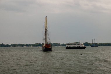 Fırtınadan önce güverteden pruvaya, sakin su ve fırtına bulutları şehrin panoramasına yaklaşıyor. Sert hava, dramatik gökyüzü, gök gürültülü fırtına, kara bulutlar. Toronto, Ontario, Kanada