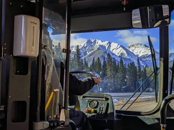 Tanımlanamayan bir otobüs şoförü, dağların içindeki bir otoyolda servis otobüsü kullanıyor. Dağ ulaşımı. Meslek konsepti - otobüs şoförü.