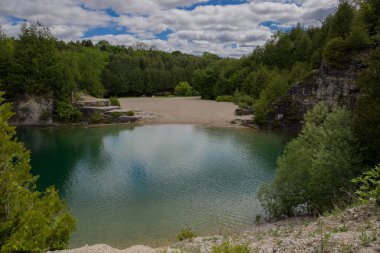 Elora taş ocağı. Ormanı, kayaları ve inanılmaz mavi berrak suları olan bir yer. Aktivite için popüler bir yer. Yüzme, yürüyüş ve nehirde balık tutma. İnsansız güneşli bir yaz günü. Elora, Ontario, Kanada