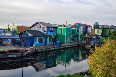 Renkli yüzen evler ve modern binalar Victoria, BC, Kanada 'daki Fisherman' s Wharf 'ın rıhtımında yer alıyor.