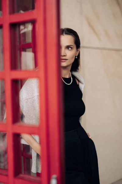 Joven Mujer Bonita Vestido Negro Entra Puerta Roja Contra Fondo —  Fotos de Stock