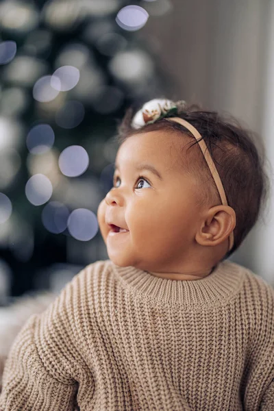 クリスマスライトを背景に幸せな混合レースの赤ちゃんの女の子の肖像画 ボケ効果あり 異人種間の家族と団結の概念 — ストック写真