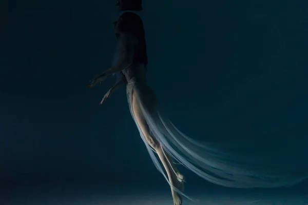 白い飛行中の美しい女性の水中撮影透明なドレス太陽の光を介して水の中で泳ぐ 光の光線で水面を背景に幻想的な人魚 — ストック写真
