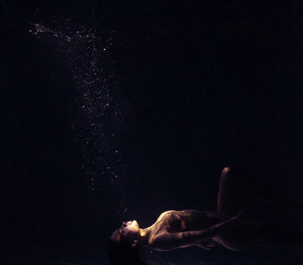 美しい女性の水中撮影は 日光浴で水の中でリラックス 光の光線で水面を背景に幻想的な人魚 — ストック写真