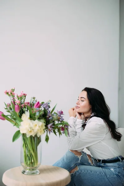Fiatal Gondolkodó Karosszék Hátterében Gyönyörű Csokor Virág Asztalon Anyák Napja — Stock Fotó