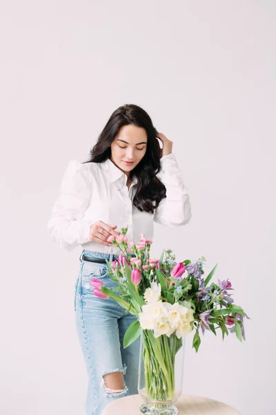 Fiatal Boldog Áll Gyönyörű Virágcsokor Mellett Asztalon Fehér Háttér Mellett — Stock Fotó