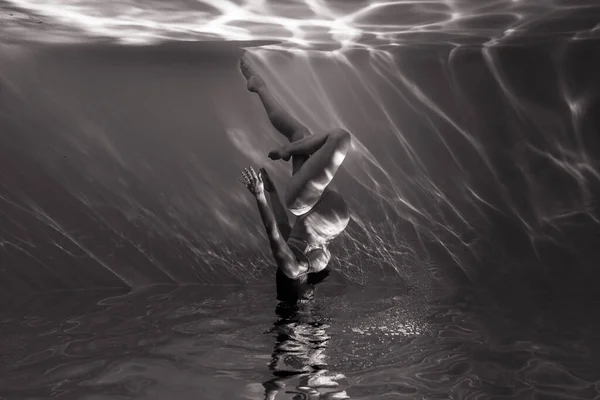 陽射しの中で水の中で踊る美しい妊婦の水中撮影 光の光線と水の背景にファンタジー人魚 白黒の画像 — ストック写真