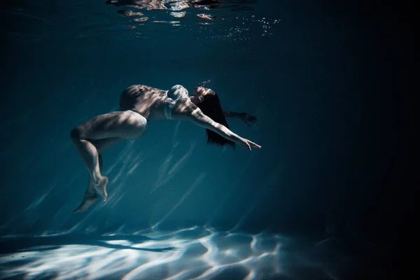 美丽的孕妇在水下拍摄的照片 通过阳光在水里游泳 幻想美人鱼与绿松石水底的光芒 — 图库照片