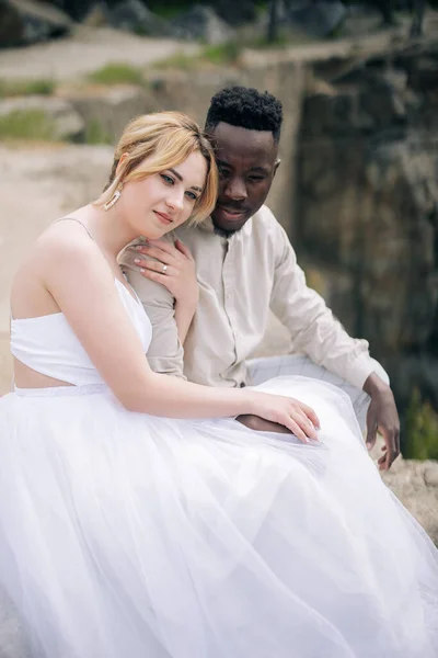 Soñando Pareja Interracial Recién Casados Sienta Roca Contra Fondo Del —  Fotos de Stock