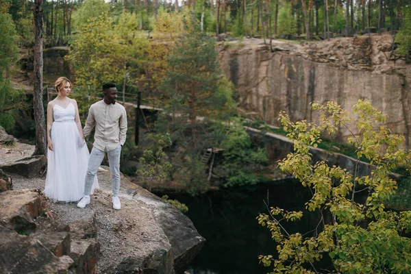 Irklar Arası Mutlu Çift Yeni Evliler Kayaların Üzerinde Duruyor Gölün — Stok fotoğraf