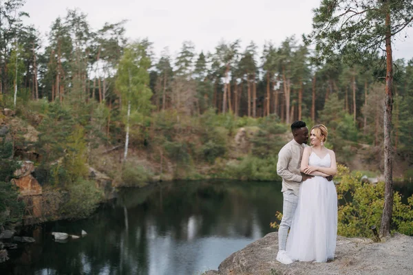 幸せな異人種間のカップル新婚夫婦は岩の上に立って 峡谷の背景を包含します 異なる人種間の愛の関係と団結の概念 — ストック写真