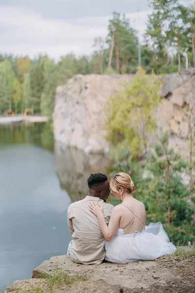 Feliz Pareja Interracial Recién Casados Sienta Roca Abraza Sobre Hermoso — Foto de Stock