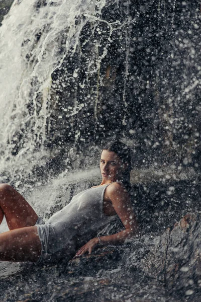 Jovem Mulher Vestido Molhado Deitado Rocha Desfrutando Perto Cachoeira Entre — Fotografia de Stock
