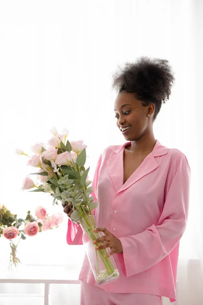 Young African Joyful Woman Pink Pajamas Standing Room Flower Bouquet Stock Image