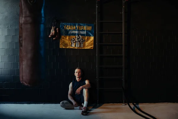 Idrottare Vilar Mörkt Gym Efter Träning Mot Bakgrund Ukrainska Flagga — Stockfoto