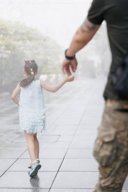 Küçük Ukraynalı kız, tatilde babası ile tanışır, onu kucağına alır ve ona yol gösterir. Arkadan bak. Ukrayna 'da savaş. Rus ordusu Ukrayna 'yı işgal etti. Savaş ve çocuklar.