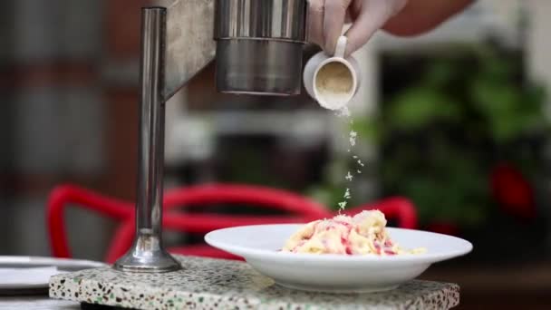 咖啡店的工作人员将切碎的坚果撒向用果汁倒入的冰淇淋中 手工制作的冰淇淋 — 图库视频影像