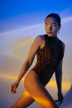 Mavi arka planda poz veren takım elbiseli güzel bir kadın. Yakın plan..