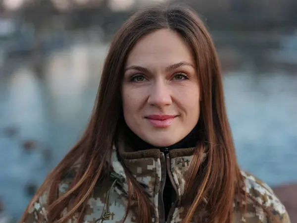 Portrait of Ukrainian woman soldier resting in park during her vacation near lake. Women and war in Ukraine.Russian military invasion in Ukraine.