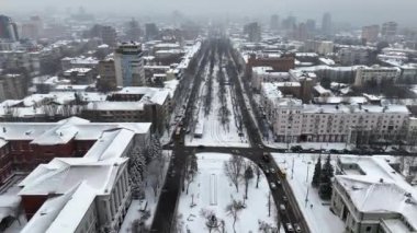 Ukrayna 'daki Kış Dinyeper şehri ve kar yağış sırasında kuş bakışı manzaralı araçlarla kaplı cadde. Yolların ve gökdelenlerin hava aracı görüntüsü. Karla kaplı şehirde hava manzarası.