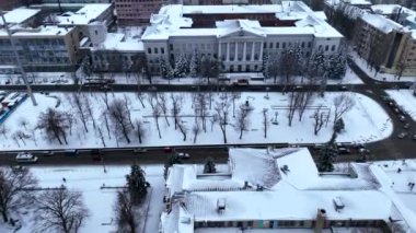 Ukrayna 'daki Kış Dinyestarı şehri ve karla kaplı cadde kuş bakışı yoldan geçen arabalarla dolu. Yolların ve binaların hava aracı görüntüsü. Karla kaplı şehirde hava manzarası.