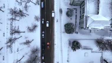 Ukrayna 'nın Dinyeper şehrinin yukarısından kış ayına kadar olan kısmı ve karla kaplı caddeleri kuş bakışı araba trafiğiyle görüyoruz. Yolların ve binaların hava aracı görüntüsü. Karla kaplı şehirde hava manzarası.