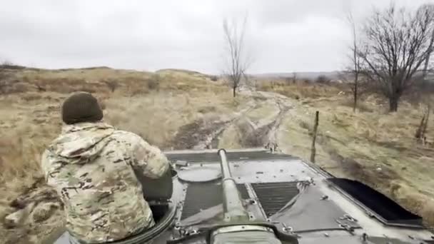 ウクライナ戦士との歩兵戦闘車両は 前線の汚れた道路に沿って移動するハッチで 戦闘車のタレットからの眺め バックビュー ロシア軍によるウクライナ侵攻 ウクライナ戦争 — ストック動画