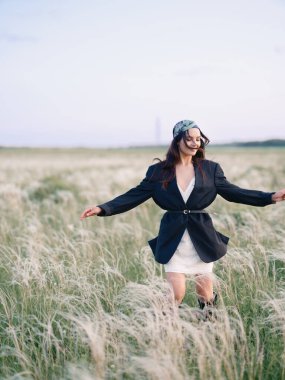 Genç bir kadın bozkırda, güzel manzaranın tadını çıkarıyor, rahatlıyor ve keyif alıyor. Ukrayna 'da bozkır çimenli yaz manzarası.