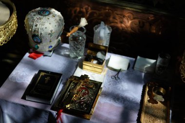 Bir kilise ayini sırasında sunağın üzerine yerleştirilmiş altın bir Ortodoks haçı. Karmaşık detaylar, sıcak ışık ve Ortodoks Hıristiyan geleneğinin kutsal atmosferi.