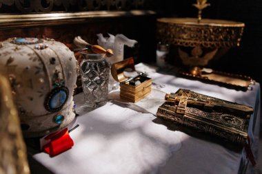 Bir kilise ayini sırasında sunağın üzerine yerleştirilmiş altın bir Ortodoks haçı. Karmaşık detaylar, sıcak ışık ve Ortodoks Hıristiyan geleneğinin kutsal atmosferi.