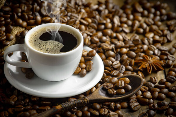 Coffee beans, on an old background in a spoon.
