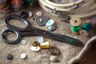 Renkli iplikler ve dikiş için ögeler, eski bir arkaplanda.