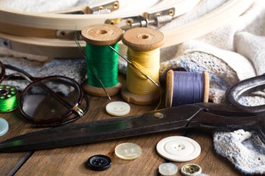 Renkli iplikler ve dikiş için ögeler, eski bir arkaplanda.