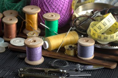 Renkli iplikler ve dikiş için ögeler, eski bir arkaplanda.