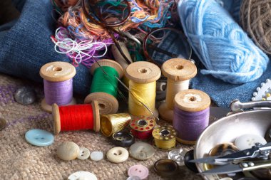 Renkli iplikler ve dikiş için ögeler, eski bir arkaplanda.