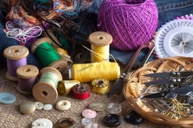 Renkli iplikler ve dikiş için ögeler, eski bir arkaplanda.