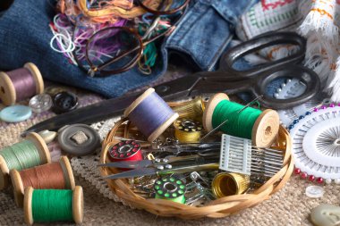 Renkli iplikler ve dikiş için ögeler, eski bir arkaplanda.