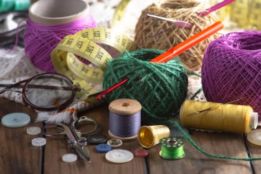 Renkli iplikler ve dikiş için ögeler, eski bir arkaplanda.