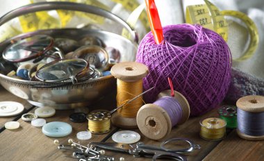 Renkli iplikler ve dikiş için ögeler, eski bir arkaplanda.