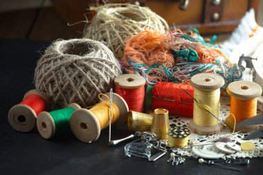 Renkli iplikler ve dikiş için ögeler, eski bir arkaplanda.