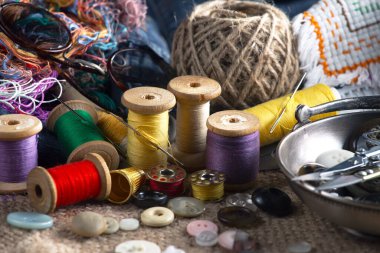 Renkli iplikler ve dikiş için ögeler, eski bir arkaplanda.