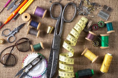 Renkli iplikler ve dikiş için ögeler, eski bir arkaplanda.