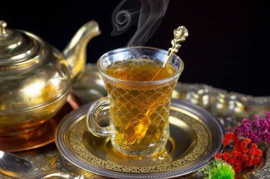 Arka planda bir fincan sıcak tatlı çay