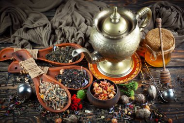 Eski bir arka planda kaşıkta kuru çay yaprakları.