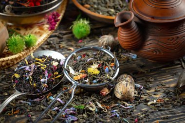 Eski bir arka planda kaşıkta kuru çay yaprakları.